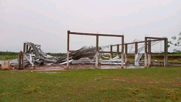 Estructura colapsada afectada por el temporal, con escombros esparcidos y cielo nublado.