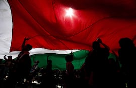 Personas sostienen una bandera durante una marcha en apoyo a Palestina pidiendo el fin de la ofensiva israelí en Gaza este martes, en Santiago, Chile.