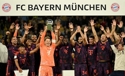 El guardameta alemán del Bayern Múnich Manuel Neuer (C) levanta el trofeo mientras celebra con sus compañeros la victoria en la Supercopa Franz Beckenbauer entre el Borussia Dortmund y el FC Bayern Múnich, en Dortmund, en el oeste de Alemania.