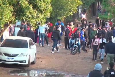 Treinta personas, la mayoría con abrigo, rodean una motocicleta en un ambiente de preocupación tras disturbios.