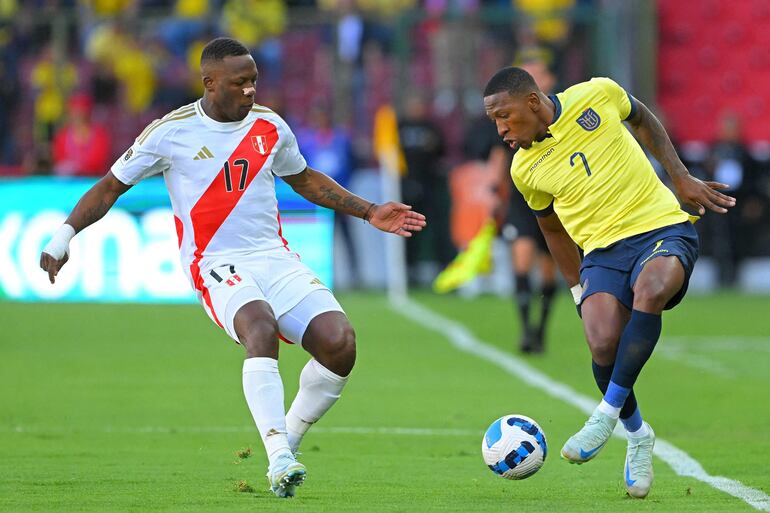 Luis Advíncula (i), jugador de la selección de Perú, pelea por el balón en el partido frente a Ecuador por la octava fecha de las Eliminatorias Sudamericanas en el estadio Rodrigo Paz Delgado, en Quito, Ecuador.