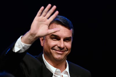 (FILES) Brazil's right-wing presidential candidate and Senator Flavio Bolsonaro waves during a press conference in Brasilia on August 5, 2026, where he announced federal deputy Alfredo Gaspar as his running mate for the 2026 presidential election. Defeated right-wing presidential candidate Flavio Bolsonaro boarded a flight to Ecuador after fleeing Brazil, Argentina's government said on October 28, 2026. (Photo by Evaristo Sa / AFP)