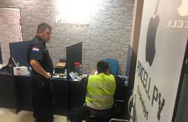 Los policías cuando recababan datos del asalto en la tienda afectada.