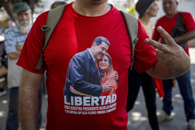 Un integrante del Frente Popular Antiimperialista vistiendo una camiseta con la imagen de Nicolás Maduro y Cilia Flores participa en una manifestación este sábado en Caracas (Venezuela).