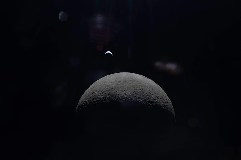 Esta imagen difundida el 9 de abril de 2026 por NASA muestra una tenue vista de la Tierra en fase creciente sobre el horizonte del lado oculto de la Luna, fotografiada por la tripulación de Artemis II desde la nave Orion el 6 de abril de 2026. Los astronautas de Artemis II realizaron un histórico sobrevuelo lunar, recopilaron datos de gran valor y captaron vistas inéditas de la Luna, pero uno de los momentos más cruciales de su misión de 10 días aún está por llegar: su amerizaje el 10 de abril.