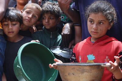 Niños esperan recibir comida en un campo de desplazados en la Ciudad de Gaza, ayer jueves.