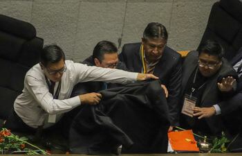 Varios hombres protegen al vicepresidente de Bolivia, David Choquehuanca, mientras parlamentarios oficialistas afines al expresidente de Bolivia Evo Morales (2006-2019) le lanzan tomates y plantas, hoy, durante una sesión en la Asamblea Legislativa, en La Paz (Bolivia). Los parlamentarios impidieron con violencia la instalación de la sesión legislativa en la que el presidente del país, Luis Arce, debía presentar un informe de gestión al cumplir cuatro años de Gobierno e iniciar el quinto y último de su gestión. EFE/ Gabriel Márquez