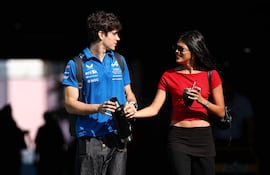 ¡De la manito! Franco Colapinto y Maia Reficco llegando al paddock antes del sprint previo al Gran Premio de Fórmula 1 de Miami en el Autódromo Internacional de Miami. (Chris Graythen/Getty Images/AFP)