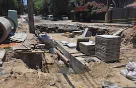 Enorme cráter con escombros, materiales de construcción y agua servida, sobre Nuestra Señora del Carmen.