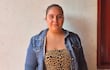 Mujer con chaqueta de mezclilla y camiseta leopardo frente a una pared blanca, con expresión neutral y cabello recogido.