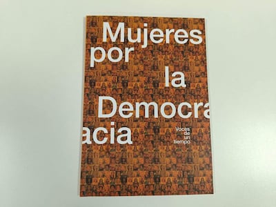 'Mujeres por la Democracia' en letras grandes blancas sobre un fondo de rostros femeninos, resaltando su representación.