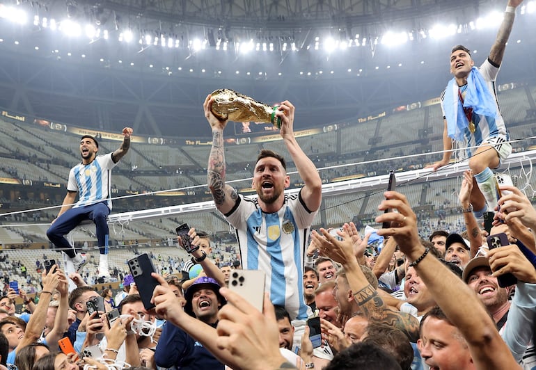 Lionel Messi (c), jugador de la selección de Argentina, celebra con el trofeo de campeón la conquista del Mundial Qatar 2022 en el Lusail Stadium, Lusail, Qatar. 