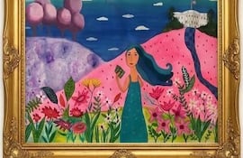 Mujer de cabello largo y ondulado viste un vestido verde claro, sosteniendo un libro en un jardín colorido con un fondo arquitectónico.