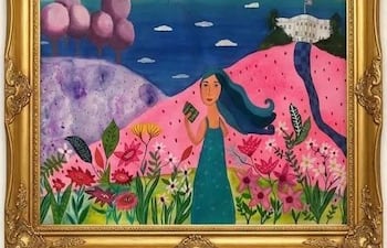 Mujer de cabello largo y ondulado viste un vestido verde claro, sosteniendo un libro en un jardín colorido con un fondo arquitectónico.