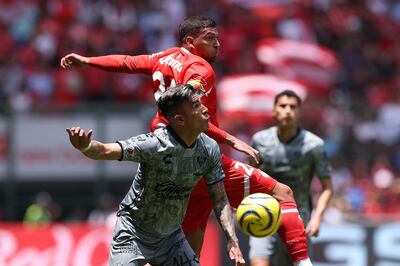 MEX3659. TOLUCA (MÉXICO), 07/04/2024.- Luis Reyes (adelante), del Atlas, disputa un balón con Juan Escobar (atrás), del Toluca, este domingo durante un juego por la jornada 14 del torneo Clausura 2024 de la Liga MX, en el estadio Nemesio Diez de Toluca (México). EFE/ Alex Cruz