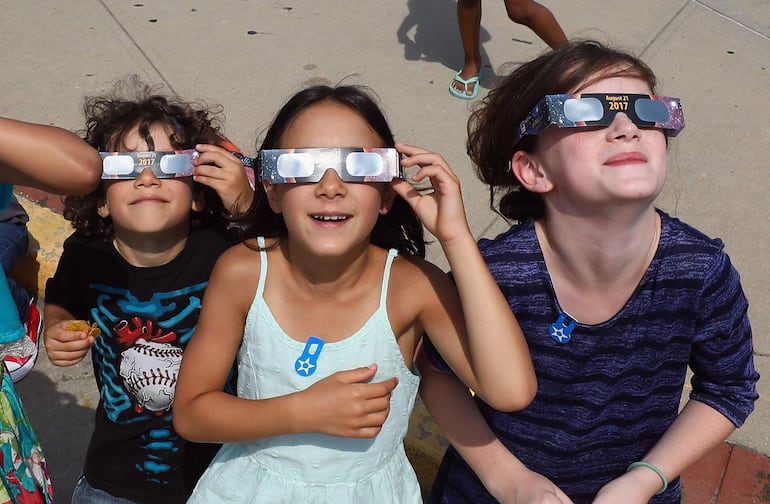 Espectadores miran hacia el cielo durante un eclipse solar parcial, el 21 de agosto de 2017, en el Museo Cradle of Aviation, en Garden City, Nueva York.