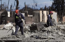 Fotografía cedida por el Departamento de Defensa de EE.UU. de miembros del Equipo de Búsqueda y Rescate Urbano de la Agencia Federal para el Manejo de Emergencias que recorren una zona destruida por los incendios, en Lahaina, Hawai (EE.UU.).