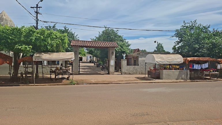 Siete agentes de la Policía Nacional, en uniforme oscuro, conversan en un terreno rural con una excavadora al fondo.