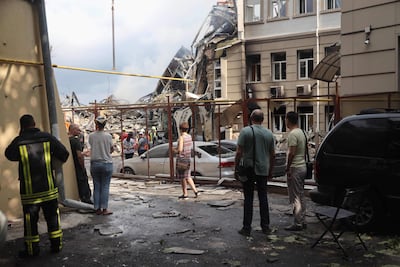 Vecinos de Odesa observan a rescatistas trabajando en los escombros de un edificio destruido por un ataque aéreo ruso, este jueves.