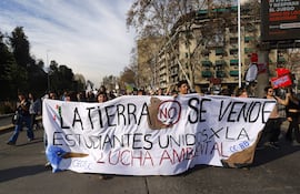 Personas sostienen un cartel durante la denominada "Marcha contra los retrocesos ambientales y por los animales" este sábado, en Santiago (Chile)