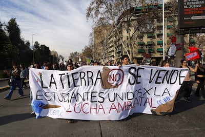 Personas sostienen un cartel durante la denominada "Marcha contra los retrocesos ambientales y por los animales" este sábado, en Santiago (Chile)