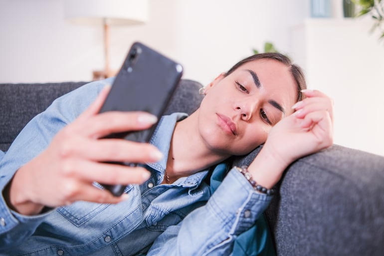 Mujer mira su celular.