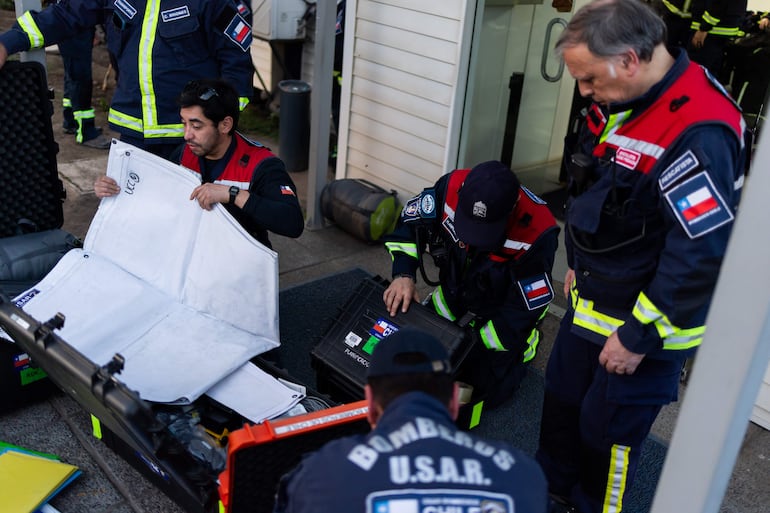 Integrantes de la Unidad Especializada de Bomberos, USAR boCH, se preparan para embarcar rumbo a Venezuela tras activar el protocolo de respuesta de ayuda humanitaria, en Santiago (Chile). 