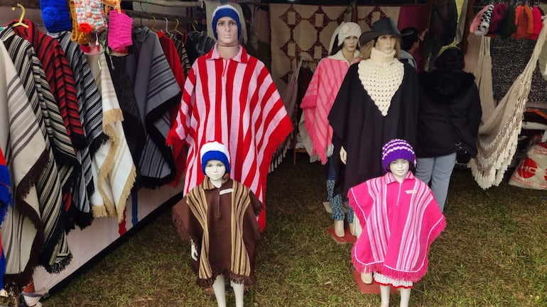 Cinco maniquíes exhiben ponchos y gorros de lana en un mercado de Festival del Ovecha Ragué.