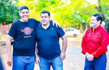 Baeza sonríe con camiseta negra, Romero escucha con expresión neutral, y Servín también sonríe con camisa roja en un entorno natural.