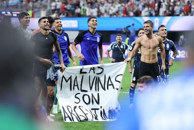 Argentina's players show a banner that reads in Spanish, "The Malvinas (Falkland Islands) belong to Argentina," after winning the 2026 World Cup football tournament semi-final match between England and Argentina at the Atlanta Stadium in Atlanta on July 15, 2026. (Photo by Thomas COEX / AFP)