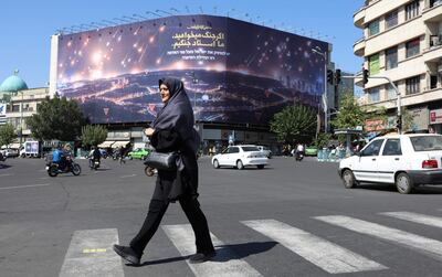 Una mujer camina cerca de un cartel que ilustra un bombardeo sobre Israel, el pasado jueves en Teherán, Irán.
