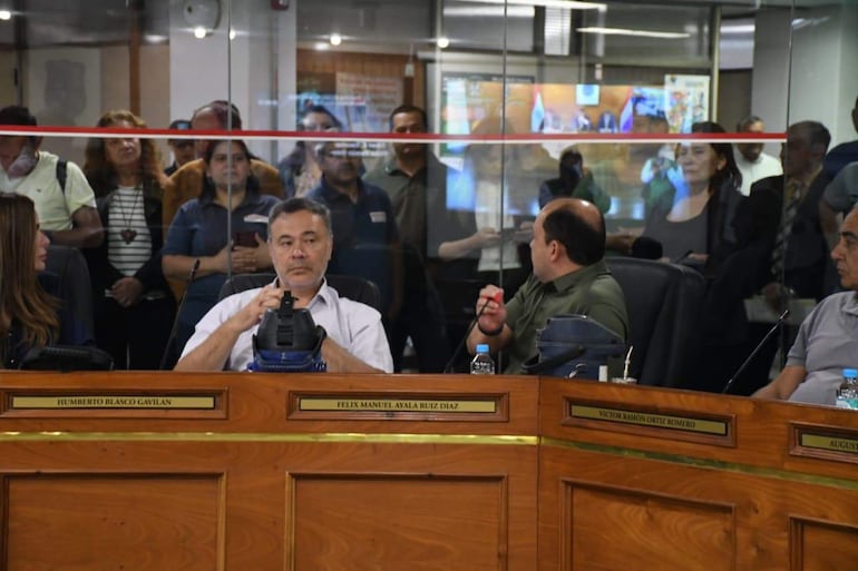 Humberto Blasco y tres personas más en una sesión, todos en un entorno formal, con expresiones tranquilas y vestimenta variada.