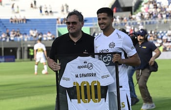 El presidente de Olimpia, Rodrigo "Coto" Nogués entrega al zaguero Mateo Gamarra la camiseta enmarcada por alcanzar 100 partidos con la franja negra.