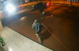 Uno de los asaltantes extiende el cordón detonante alrededor del edificio del banco Itaú de Katueté.