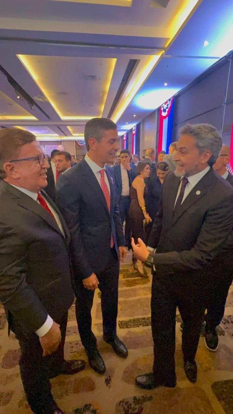 Nicanor Duarte en traje oscuro, Santiago Peña con corbata roja y Mario Abdo Benítez, todos sonrientes en un evento formal.