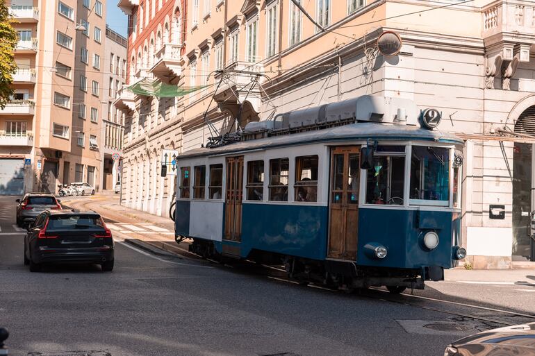 El tranvía azul Antiguas Opicina 404 pasa por la Piazza Dalmazia en Trieste, Italia.