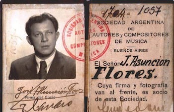 Hombre con cabello corto y oscuro, vestido formalmente, sostiene su identificación en un entorno de oficina.