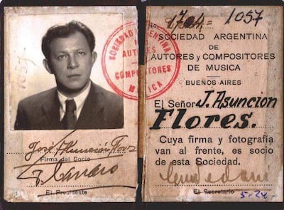 Hombre con cabello corto y oscuro, vestido formalmente, sostiene su identificación en un entorno de oficina.