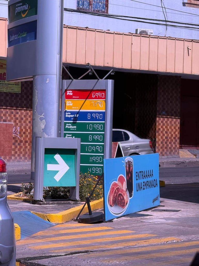 Cartel de precios de combustibles en estación de servicio, con precios de nafta y diésel, sin personas visibles.
