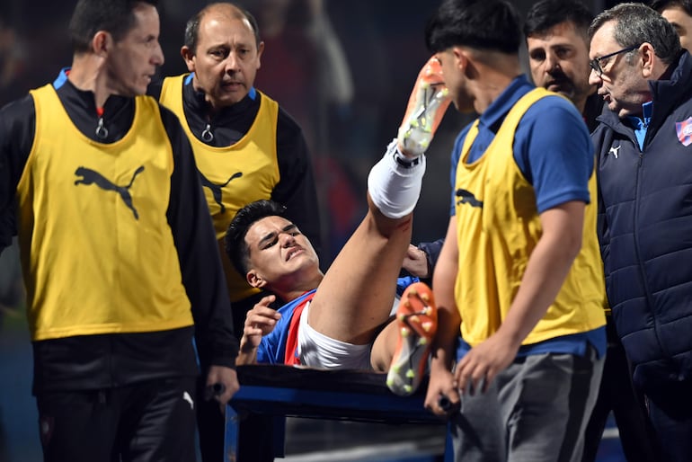 El paraguayo Rodrigo Melgarejo, jugador de Cerro Porteño, abandona en camilla el campo de juego después de sufrir una lesión en el partido contra Olimpia por la sexta fecha del torneo Clausura 2023 del fútbol paraguayo en el estadio La Nueva Olla, en Asunción. 