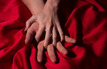 Pareja en la cama. Manos.