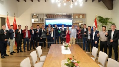 Grupo de hombres levantando el dedo índice en señal de unidad, con banderas de Paraguay y Turquía de fondo.