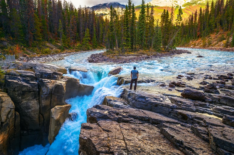 Un excursionista contempla las cataratas Upper Sunwapta en el Parque Nacional Jasper, Alberta, Canadá.