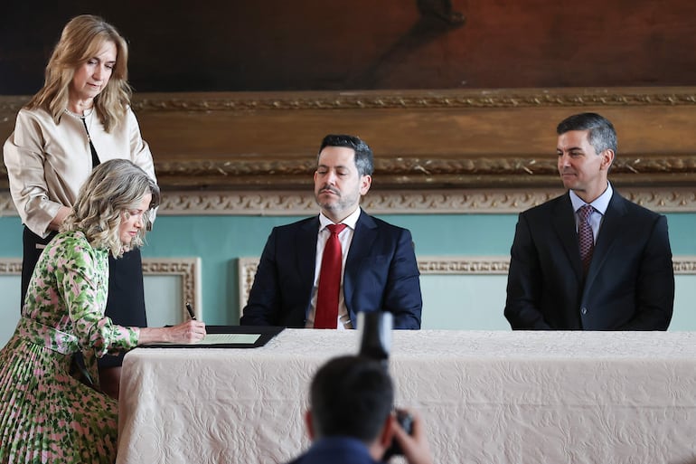 La embajadora de Paraguay ante el gobierno de Estados Unidos, Estefanía Laterza (i), firma durante la ceremonia de juramento este viernes, en Asunción.
