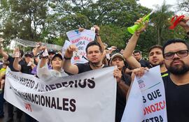 Los empleados descontratados muestran su credencial que ganaron en el concurso de Itaipú.