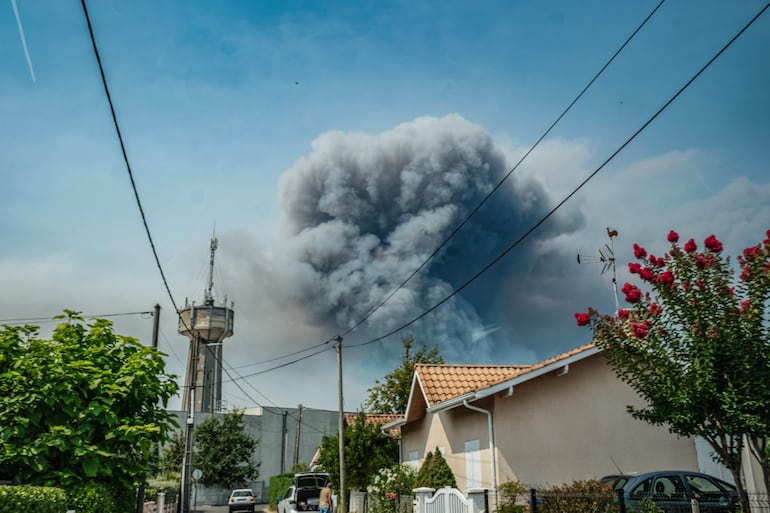Se observa el humo de un incendio forestal que se propaga por la península de Cap Ferret sobre las viviendas de Andernos, en el suroeste de Francia.