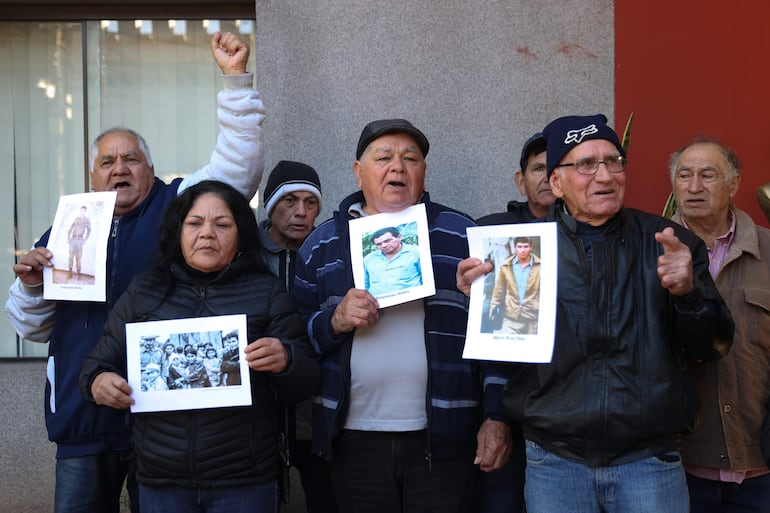 Integrantes de las Ligas Agrarias Cristianas (LAC) sostienen fotografías durante la presentación de una denuncia penal en la Fiscalía General del Estado de Paraguay este martes, en Asunción.