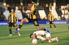 Arriesgada intervención del lateral zurdo aurinegro Alexandro Maidana que deja en el piso al liberteño Iván Ramírez.