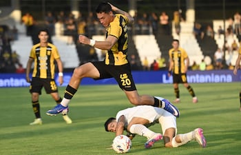 Arriesgada intervención del lateral zurdo aurinegro Alexandro Maidana que deja en el piso al liberteño Iván Ramírez.