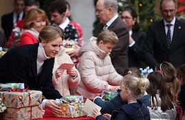 La princesa Charlene de Mónaco, junto al príncipe Jacques y la princesa Gabriella, y el príncipe Alberto II de Mónaco, distribuyeron regalos a los niños. (Valery HACHE / AFP)